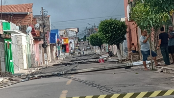 Rua amanhece com postes caídos e fios espalhados pela pista, e cena surpreende moradores